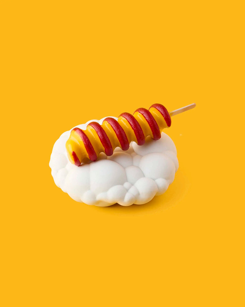 GLO Pasticceria spiral candy lollipop with alternating red and yellow stripes on a white cloud-shaped stand against a yellow background